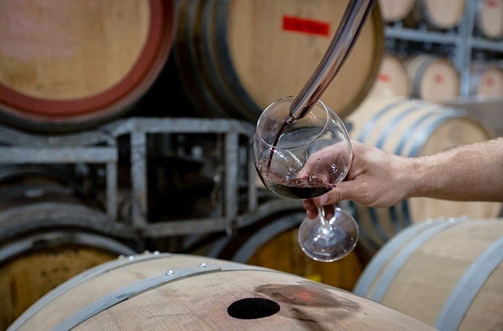Sampling rich red wine straight from the barrel at Piggs Peake's cellar door