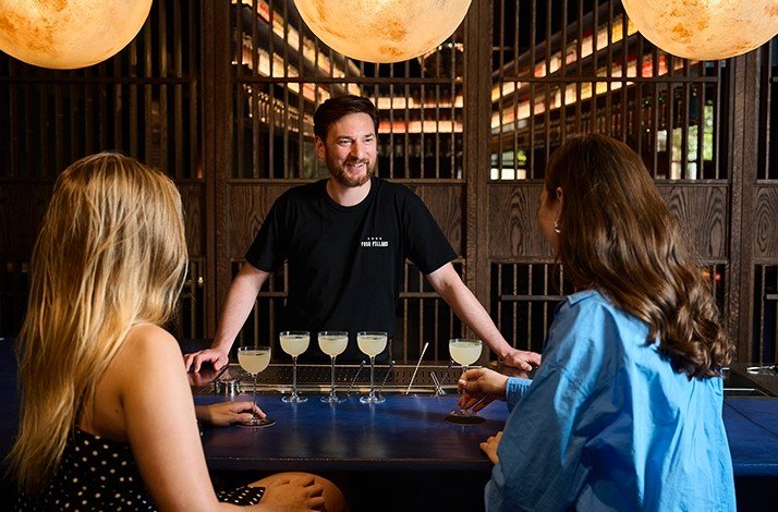 A bartender serving gin cocktails to 2 guests at the Four Pillars Gin Distillery.