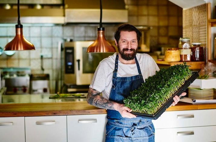 Chef Pavel Drdel at the Sůl & řepa restaurant holding tray with microgreens.