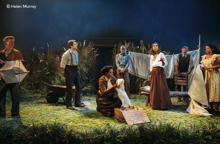 Full ensemble cast gathered on a rural summer stage set with hanging laundry and a wheelbarrow in 'A Month in the Country' at the Donmar Warehouse. © Helen Murray.