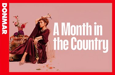 Sophie Okonedo posed with blooms and scissors in a burgundy dress beside bold white title text 'A Month in the Country' at the Donmar Warehouse.