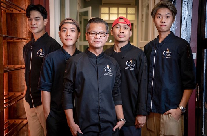 Five staff members of Chim by Siam Wisdom restaurant in restaurant’s black signature uniforms.