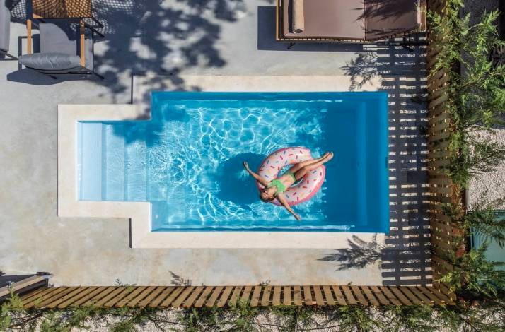 Aerial view of a person floating on a donut inflatable ring in a private pool at Polidor Camping Resort, Poreč.