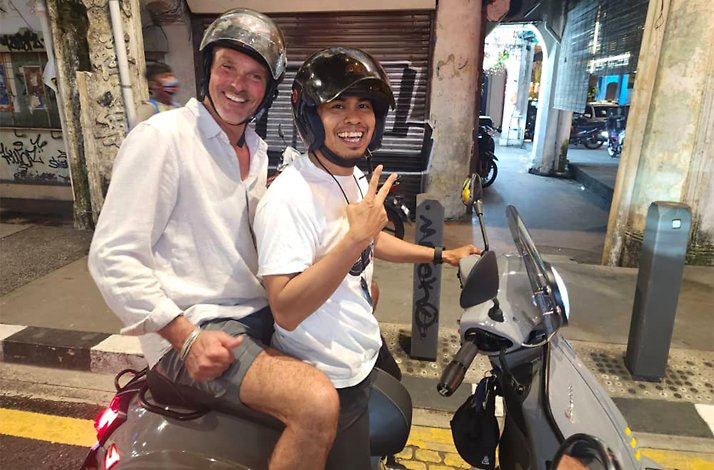 A tourist on Vespas accompanied by a guide during guided Vespa tour of Kuala Lumpur.