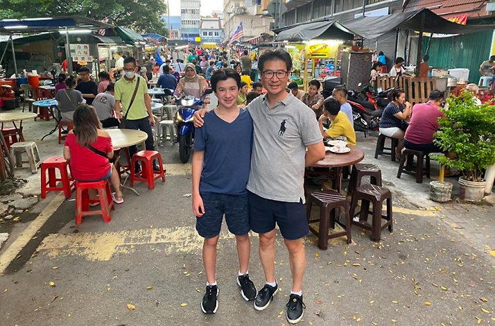 Two participants of guided vespa tour in Kuala Lumpur market.