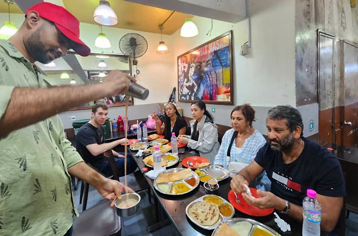 Participants form guided vespa tour having dinner at a cafeteria in Kuala Lumpur.