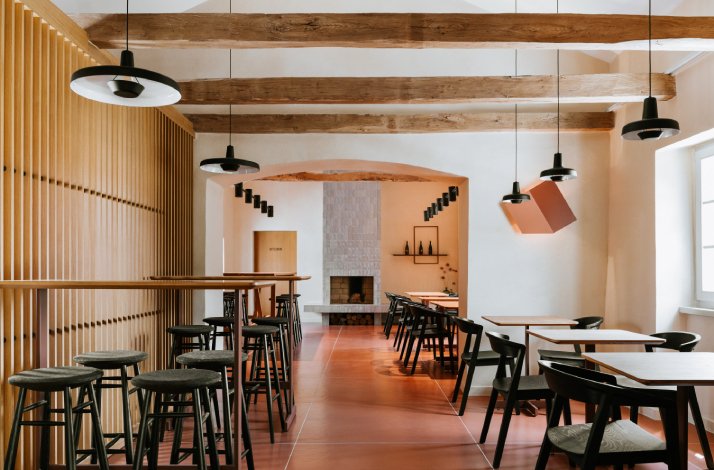 The interior of the dining hall on Ipša family estate, designed with wooden material, and featuring a fireplace.