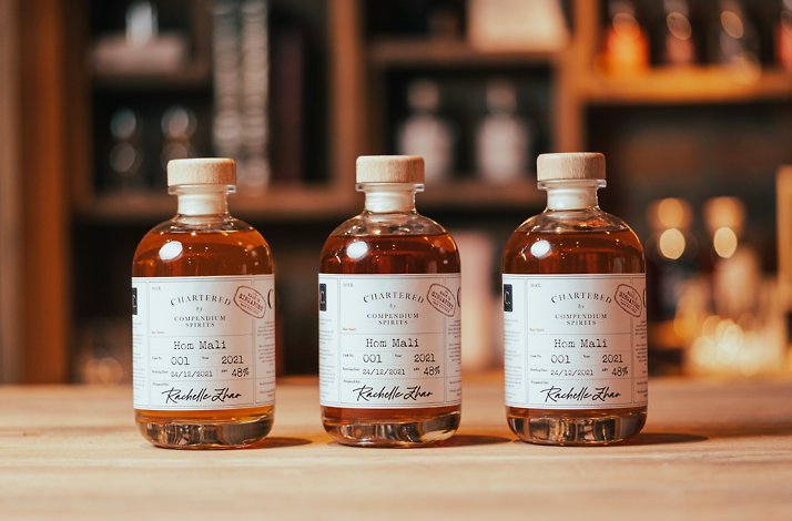 Three bottles of barrel aging spirits from Compendium Spirits on a table.