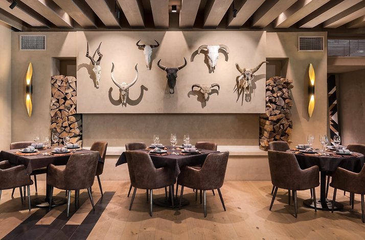 Inside the Cachava restaurant, featuring a wall adorned with mounted animal heads showcasing horns.