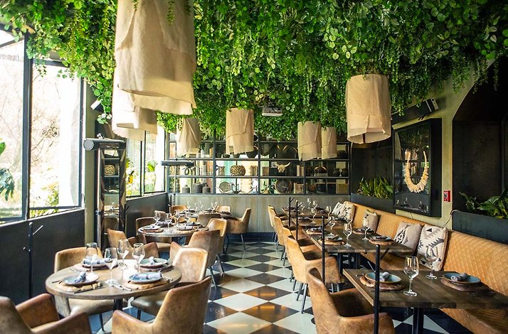 The interior of Cachava steakhouse with the celling decorated with greenery