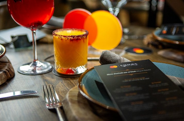 The table set in Cachava steakhouse with Mastercard decoration and red and yellow cocktails