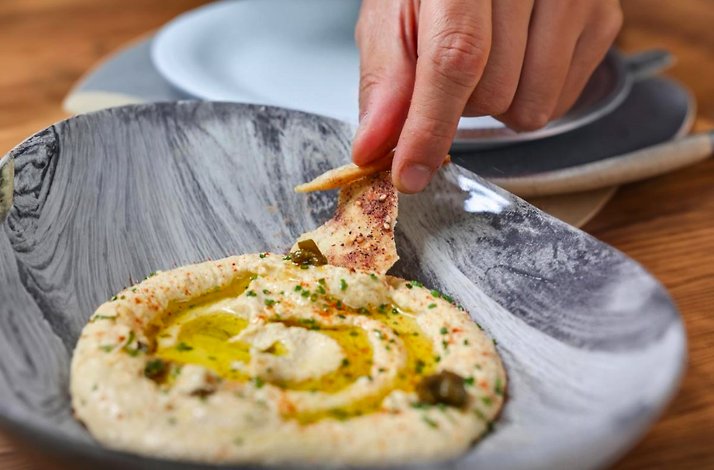 A close shot of a hummus dish with pita bread served at Mexico City's Casa Ó restaurant