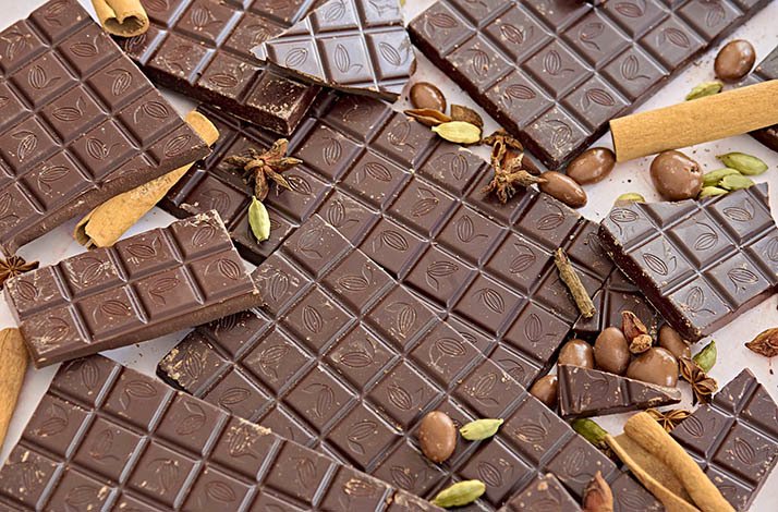 Chocolate bars made at The Lincoln Apartment Bakery on a table with nuts and cinnamon.