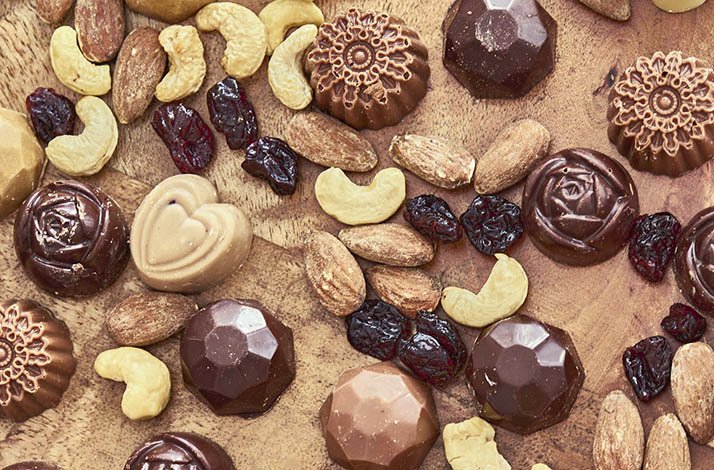 Chocolate candy made at The Lincoln Apartment Bakery on a table with nuts and raisins.