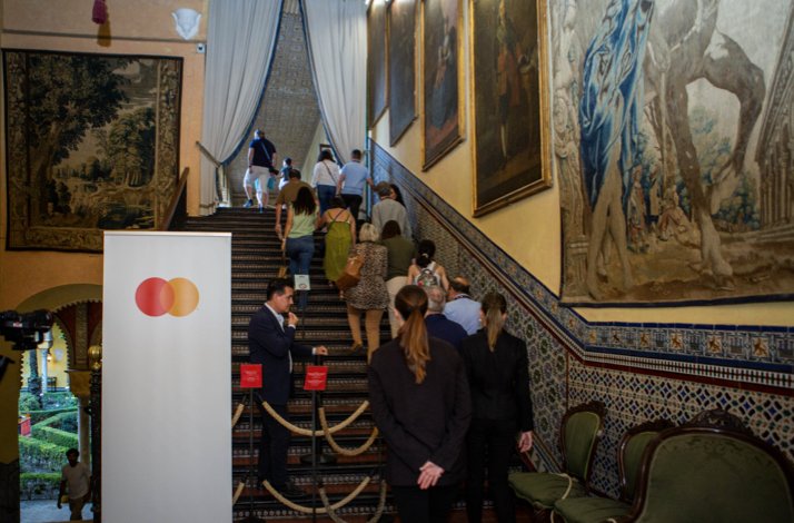 Visit Seville's Palacio de Las Dueñas with exclusive upper-floor access: In Seville, Spain The tourists next to Mastercard commercial sign going up the stairs