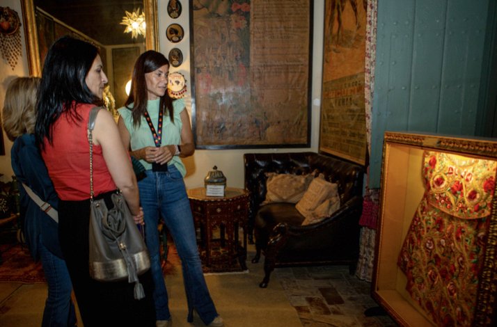 Three people looking at an art display in the halls of Palacio de las Dueñas