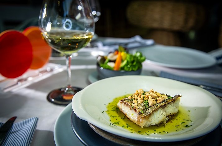 White fish served with wine and salad especially for Mastercard cardholders at Alesia Mediterraneo Restaurant.