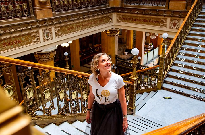 A woman standing in the stairs looking around interested in details