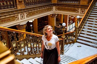 A woman standing in the stairs looking around interested in details