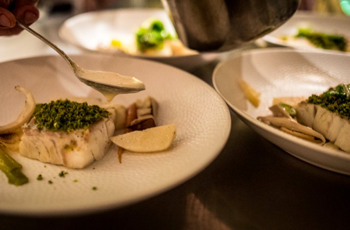 Baked fish with greenery and sauce served in Restaurant Rozemarijn