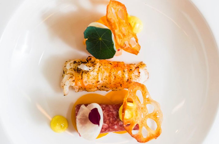 The close shot of freshly prepared haute cuisine seafood on a white plate that is served at Villa la Ruche restaurant in Voorburg, Netherlands