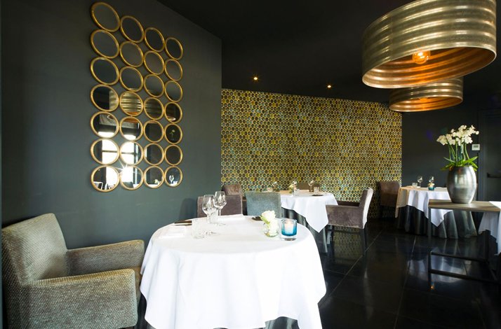 The interior of Villa la Ruche JRE restaurant, designed in green and golden colors and decorated with novelty mirrors