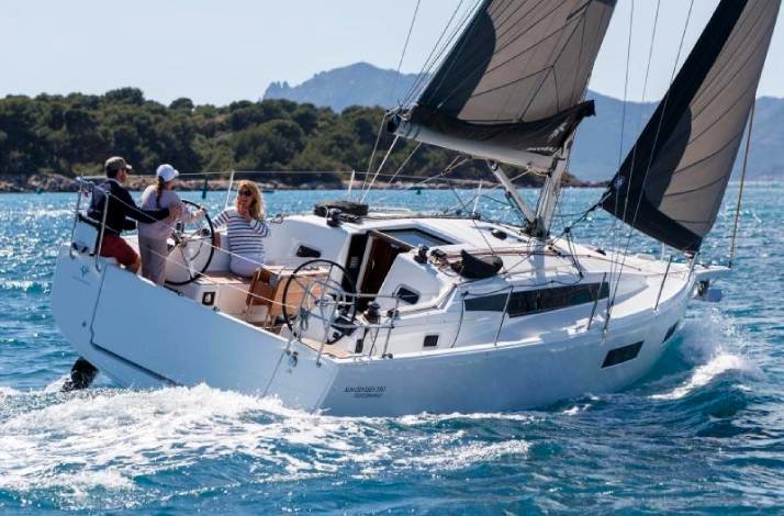 A group of people enjoying a day sailing on a sailboat under clear skies.
