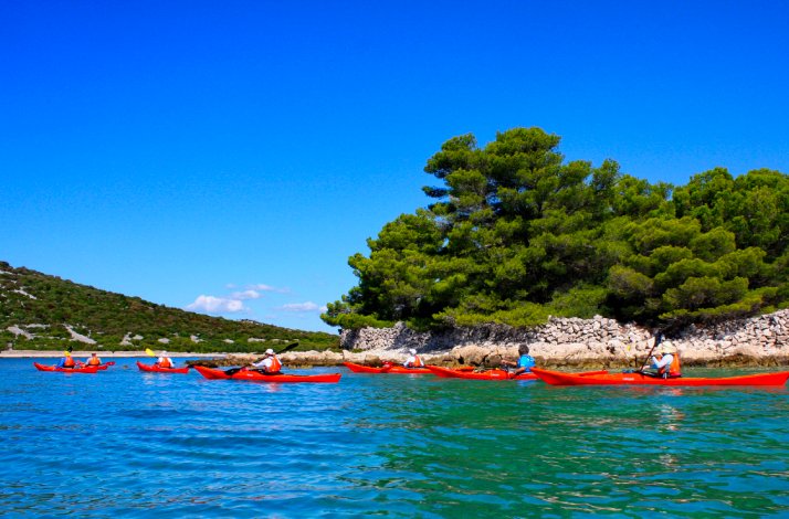 Kayak through the Šibenik archipelago on a land-and-sea adventure: In Zlarin, Croatia A group of tourists on a kayak tour of the Šibenik archipelago.