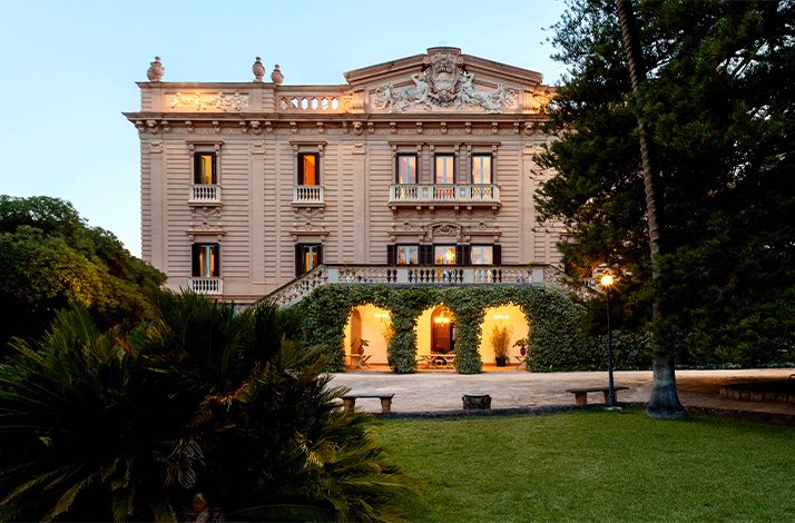 An outdoor view of the historic Villa Tasca in Palermo, captured from the front garden.