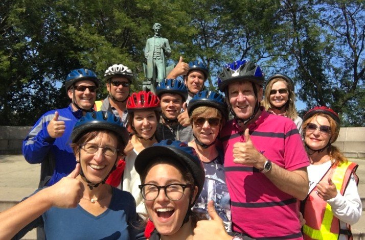 Tour group showing thumbs up to the camera next to the Lincoln Monument.