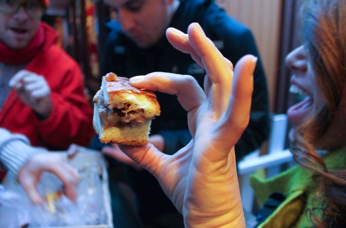 A hand holding up a sandwich with fresh meat served at Phoenix Restaurant.