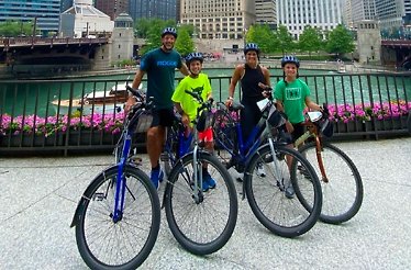 A family of four near their bikes on the Riverwalk