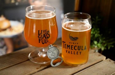 Two glasses of beer on the wooden table.