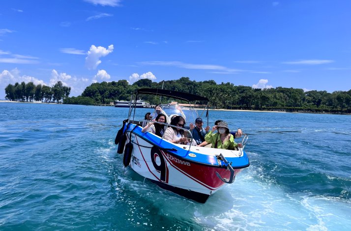 A group of tourists approaching Lazarus Island by boat.