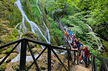 A group of travelers watching the waterfall from a ladder