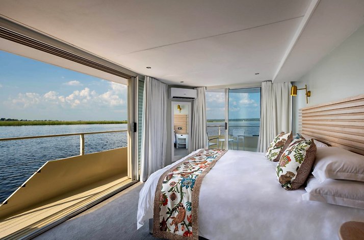 The interior of a suite on the board of Zambezi Queen Houseboat designed in light colors