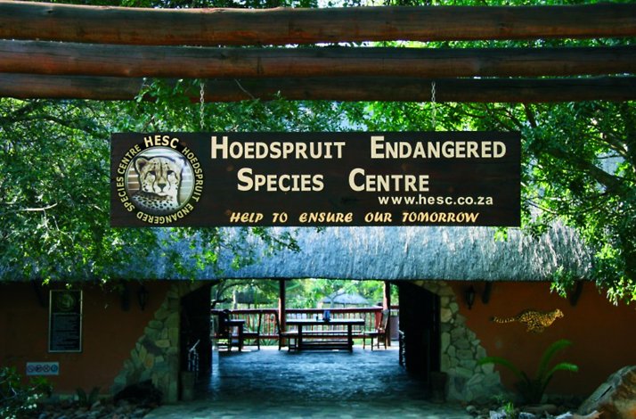 Entrance signboard at the Hoedspruit Endangered Species Centre displaying the centre's name, logo, and slogan.