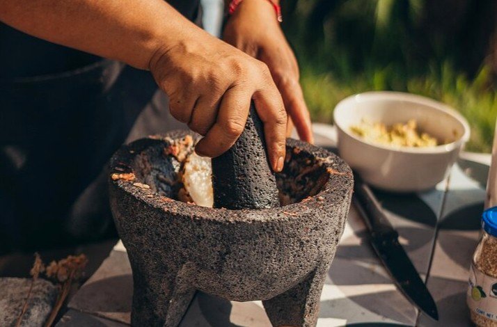 Hands of a man using a stone mortar