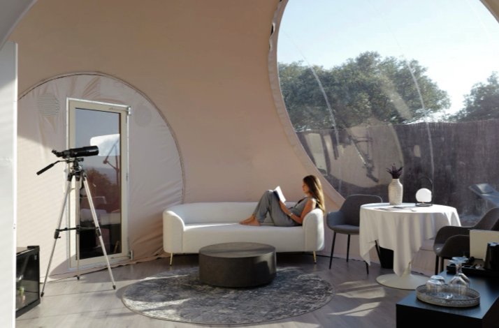Sleep under the stars in a private outdoor moon room with dinner in Toledo: In Hormigos, Spain The lady is relaxing by reading at the Miluna Open Nature Rooms.