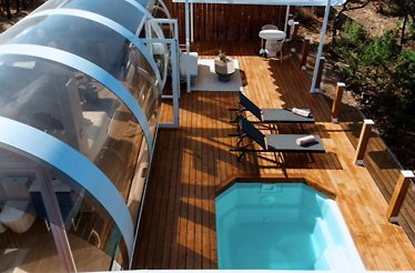 Aerial view of La Dehesa Experiences, displaying a cabin with pool and lounge chairs
