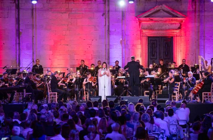 An opera gala at the Dubrovnik Summer Festival, featuring a soprano in a white dress performing with an orchestra.