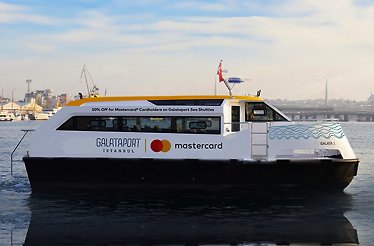 A white Galataport İstanbul Sea Shuttle ferry on the water with Mastercard branding.