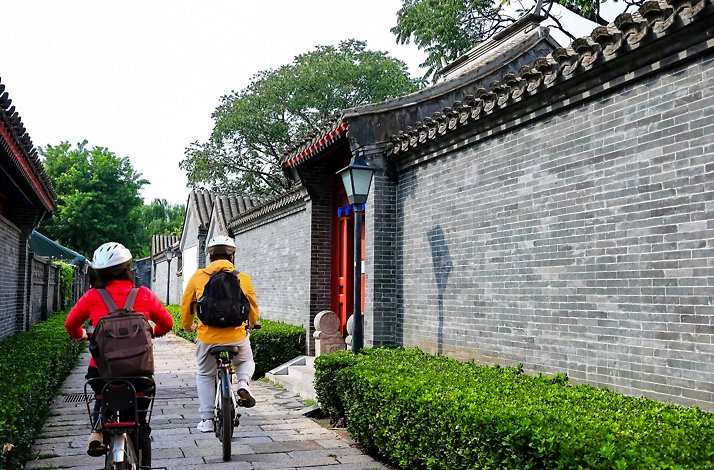 Two tourists on bikes sightseeing of historical sites during the assisted bike tour of Beijing