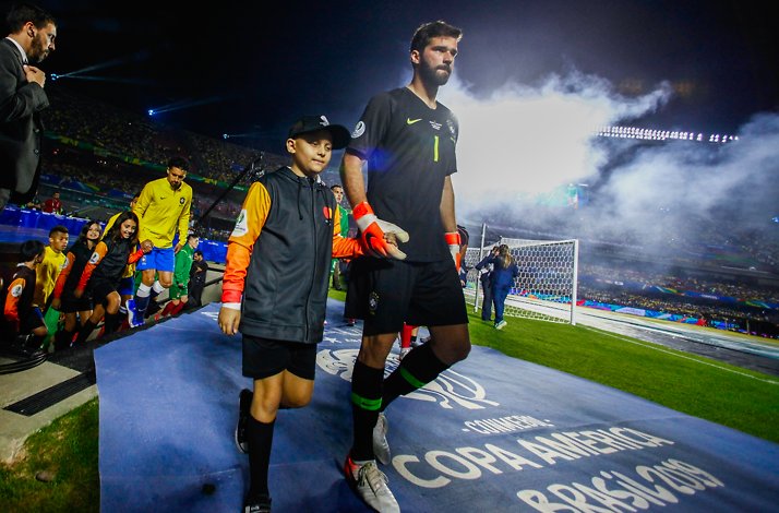 Players of Brazil national football team stepping out to the football pitch accompanied by  child player mascots