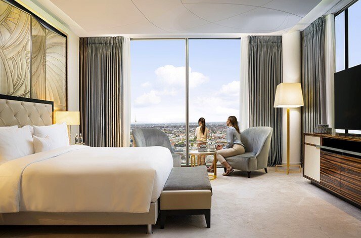A luxury bedroom suite at the Waldorf Astoria Berlin looking out over the city skyline.