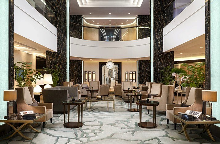 The elegant double-height lobby lounge interior of the Waldorf Astoria Berlin hotel.
