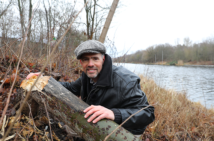 Wildlife expert Derk Ehlert poses beside a river.