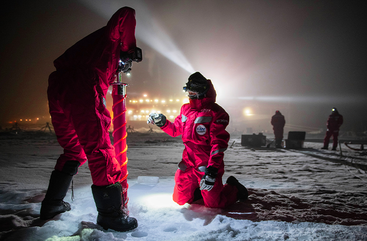 Two persons exploring Arctic during the polar expedition.