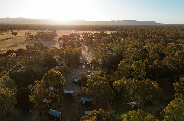 Aerial view of the Gampians with trees and the rising sun in the background