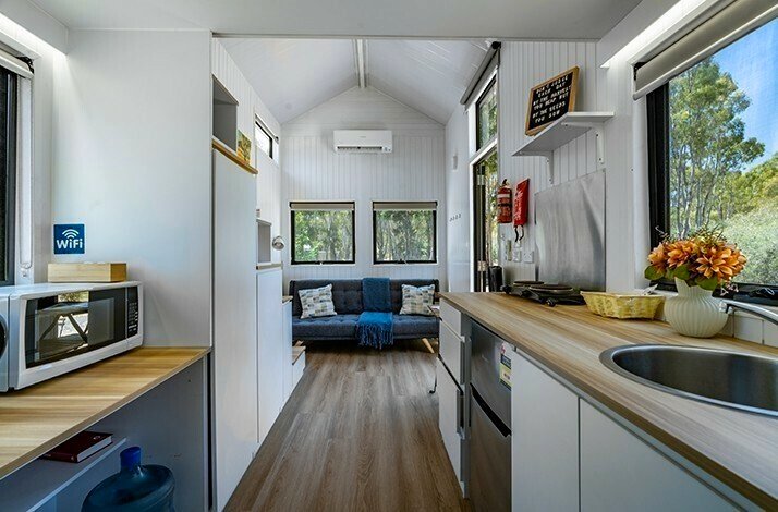 View from the inside of the tiny house in the Grampians with a kitchen and a bed.